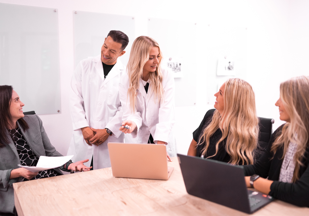 Two dentists, their team and consultants talking over computers